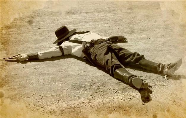 Dead gunfighter laying in street